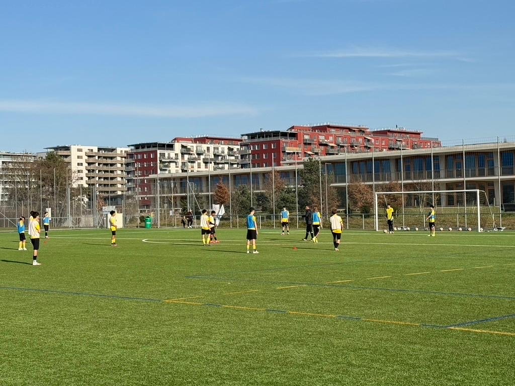 Séance d’entraînement Footeco à Genève : jeunes en chasubles jaunes et bleues autour du but, reprise 2025/2026 du GEF.